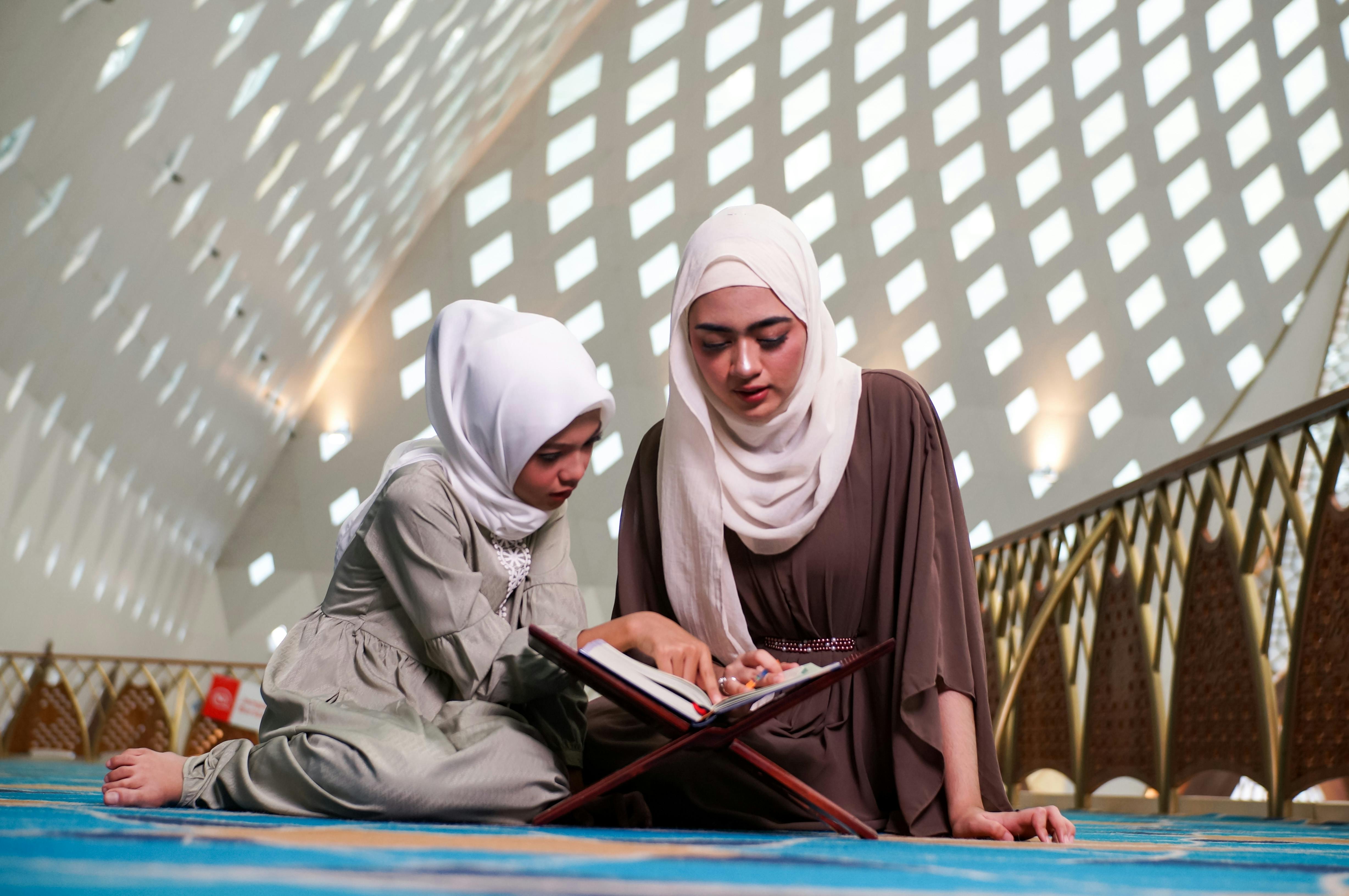 Mother and daughter reading Quran in mosque